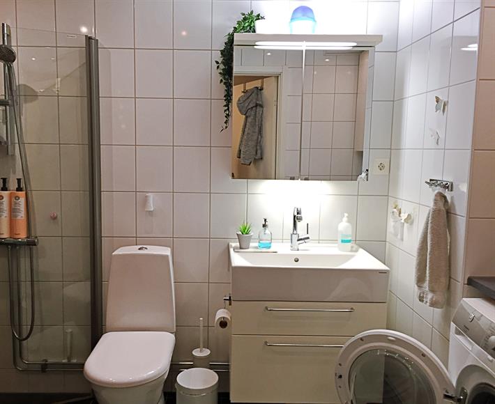 Stort och fräscht badrum med dusch, handdukstork, tvättmaskin och torktumlare.