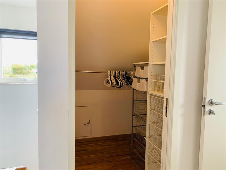 Till vänster om trappan ligger en praktisk walkin closet med tillhörande klädmoduler.
To the left of the stairs is a practical walk-in closet with built in clothing modules.