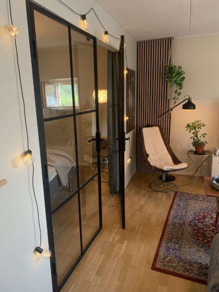 Vardagsrum med  glasdörrar in mot sovrummet