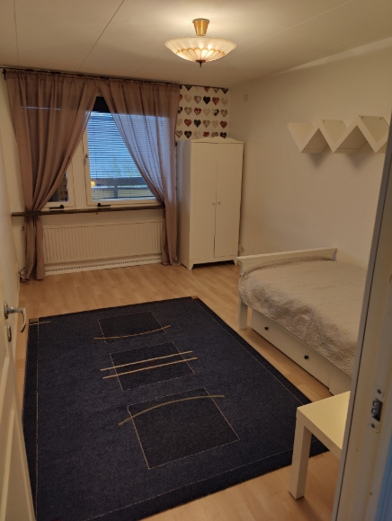 Sovrum 1 med fin matta, ett garderob och vackert taklampa.