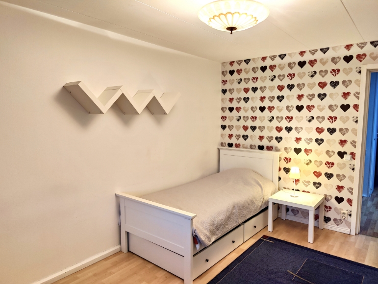 Sovrum 1 på övre plan, direkt höger om trappan. Enkelsäng (90x200) med två utdragbara förvaringslådor under sängen samt sängbord med läslampa.