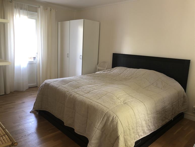 Stort sovrum med rymlig garderobsvägg och balkong på övervåningen