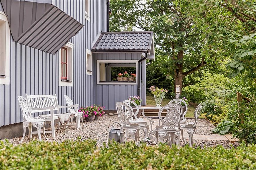 Framsida med grusplan och sittplats.