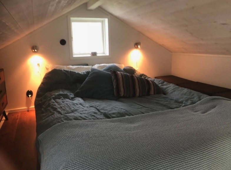 Sovloft med 140 cm säng  en våning upp som nås med en s k lofttrappa.