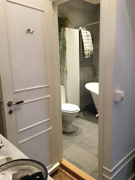 Rymligt badrum med badkar, tvättmaskin och förvaring.