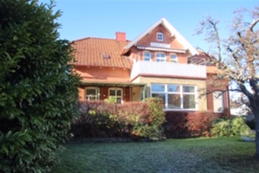 Huset sett från trädgården. Lägenheten som hyrs ut är i bottenplan.