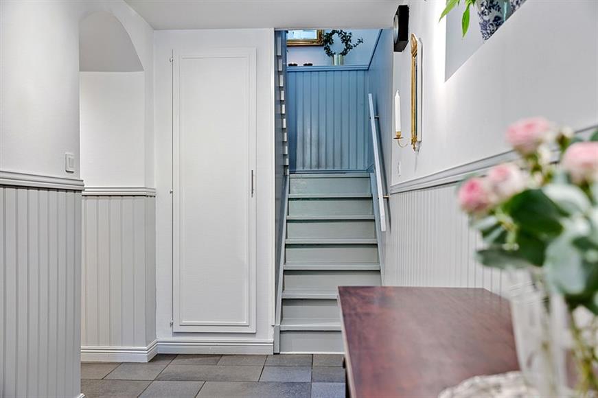 Stor inbjudande hall med förvaring under trappan och golvvärme