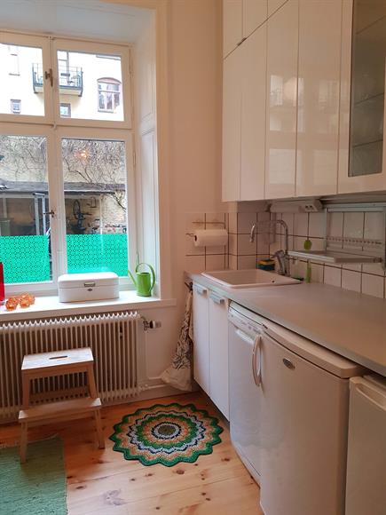Modernt vit kök med massa förvaring och en sprillans ny diskmaskin.
