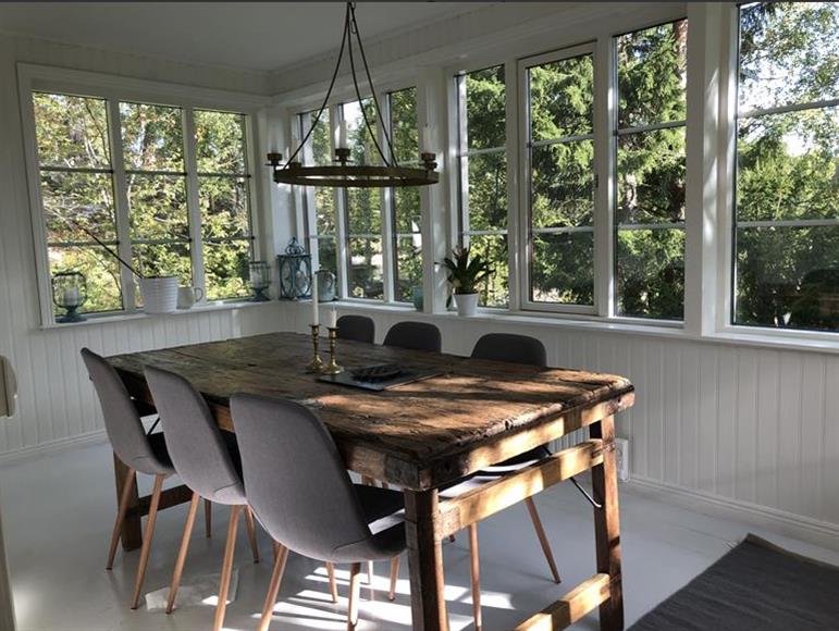 Matsal som badar i solen med plats för bord och soffa. Matsalen nås från köket