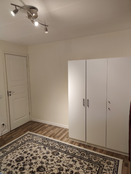 Sovrum 2, vänster om trappan på övre plan, stort garderob och fin matta.