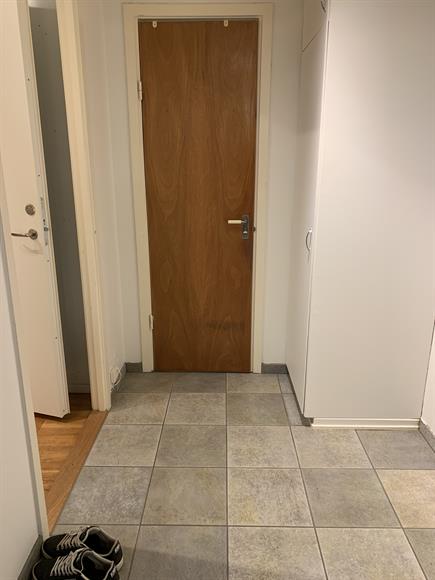 Hall med garderob. Rakt fram är badrummet och till vänster är vardagsrummet och sovrummet.
