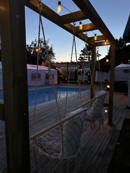 Baksida med pool och förberett tält för svensk sommar.