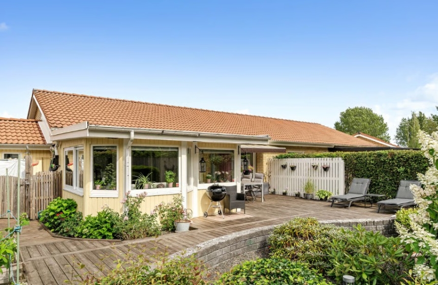 Insynsskyddad trädgård som är väldigt lättskött. Stort trädäck och stensatt rabatt.